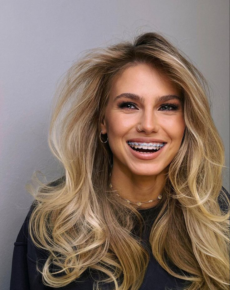 femeie blondă și frumoasă care poartă aparat dentar - zâmbitoare și cu încredere în ea