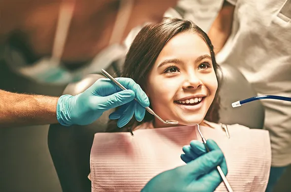 Copil zâmbind la stomatolog, sigilarea dentară este în special pentru copii