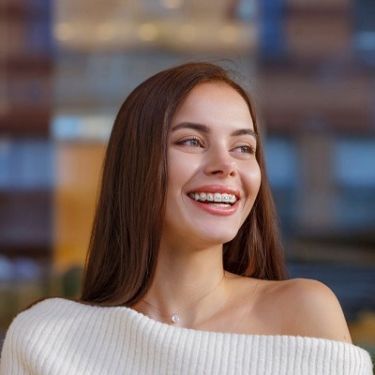 femeie brunetă și atragătoare care poartă aparat dentar.