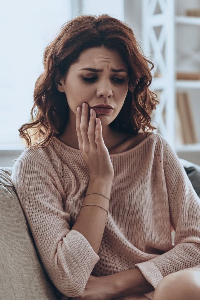 Femeie cu durere de măsea, infecție dentară, rezecția apicală poate slava dintele